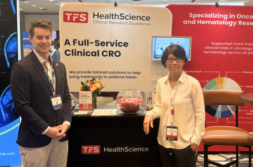Dr. Bin Pan and Maxwell Stitt from TFS HealthScience stand in front of their booth at the Clinical Trials in Oncology (CTO East Coast 2024) Conference.